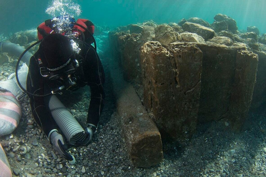 Archaeologist documenting wooden caisson (V. Tsiairis).