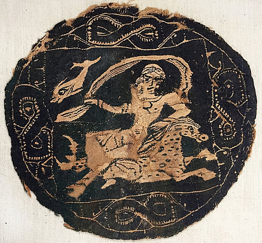 Black roundel with a nereid, or sea nymph, riding a dappled marine horse, and a dolphin behind the nereid’s shawl (Egypt, 4th-7th Century CE), natural linen and natural and black wool, 9 ½ x 9 ¾ inches (Gift of the Estate of Rose Choron, Godwin-Ternbach Museum)