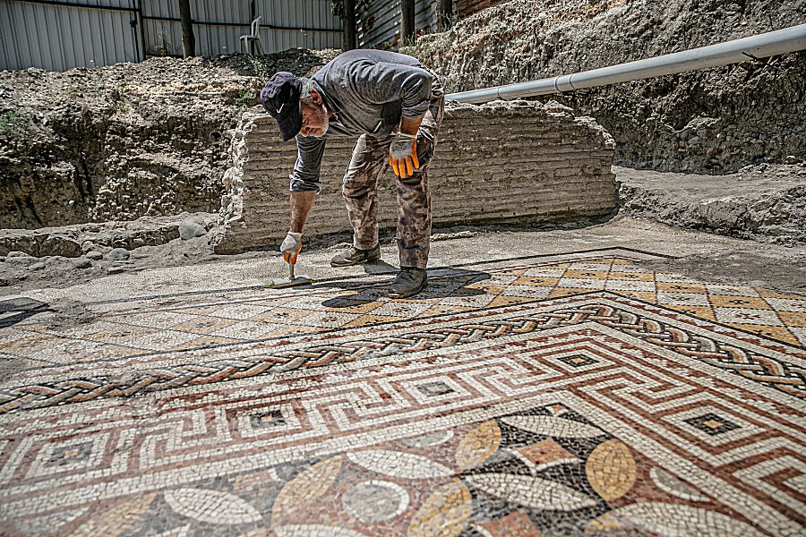 A worker cleans the mosaic on the floor of a recently discovered Roman villa in the Defne district of Hatay, southern Turkey, July 4, 2022. (AA Photo)